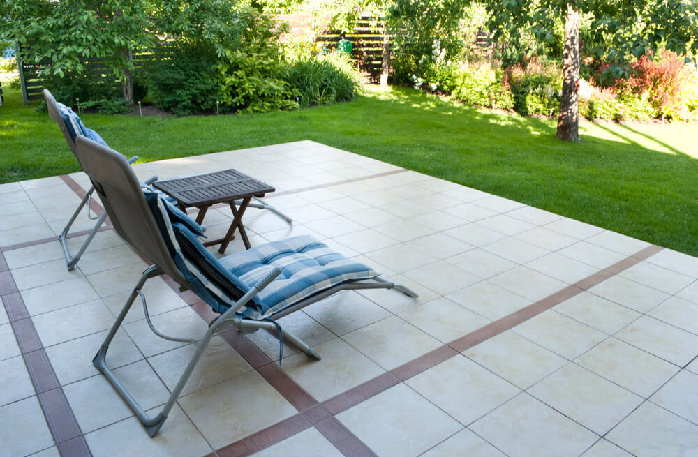 an image of two chairs sitting on a back porch that has large outdoor tiles on it that tiler Ballarat made.